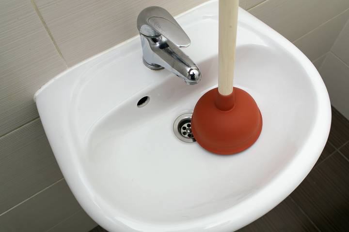 The bathroom sink smells when water runs because it is clogged.