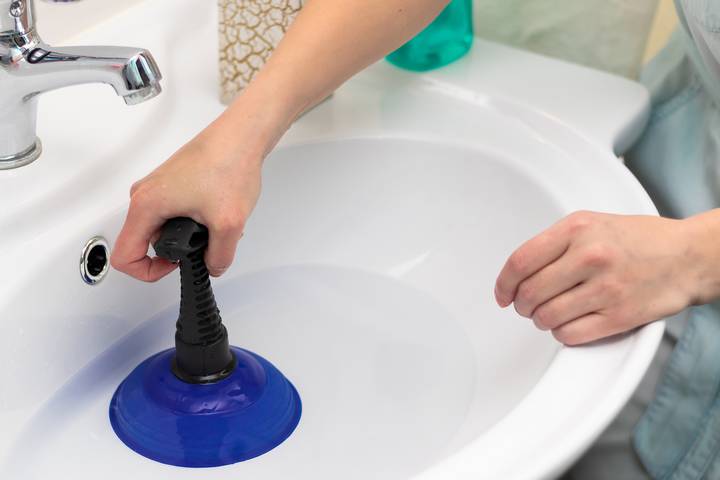 The p-trap blockage causes a slow draining bathroom sink.