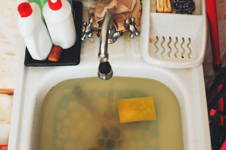 A clogged kitchen sink trap is not draining quickly.